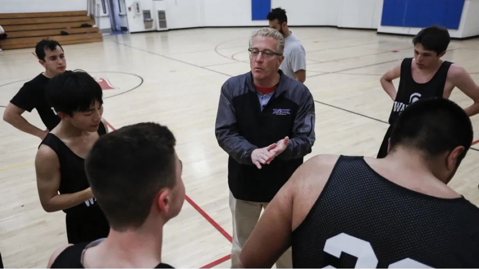 Coach Keith Luberto talking with his team in the gym